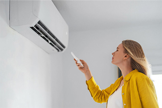 femme qui change la temperature de sa climatisation